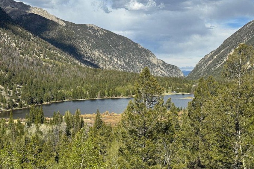 A mountainous landscape with a lake surrounded by dense forests and rugged terrain. 3