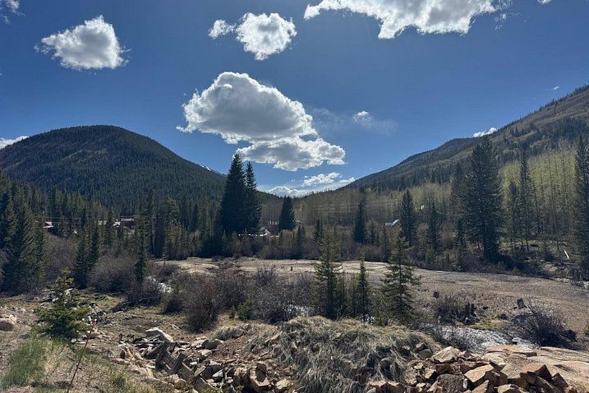 A mountainous landscape with a river, trees, and a clear sky. 5