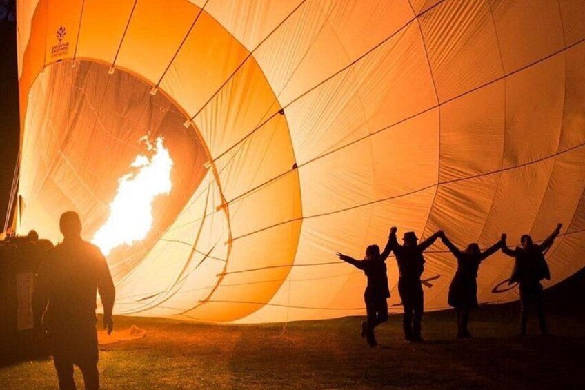 A hot air balloon with people silhouetted against it, and a visible flame inside. 4