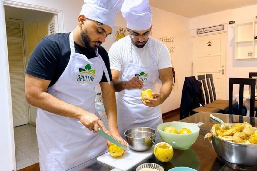 Two chefs in white aprons and hats preparing food in a kitchen. 4