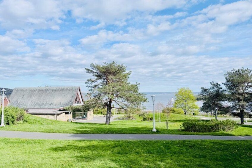 Une zone herbeuse avec un bâtiment, des arbres et un ciel dégagé. 2