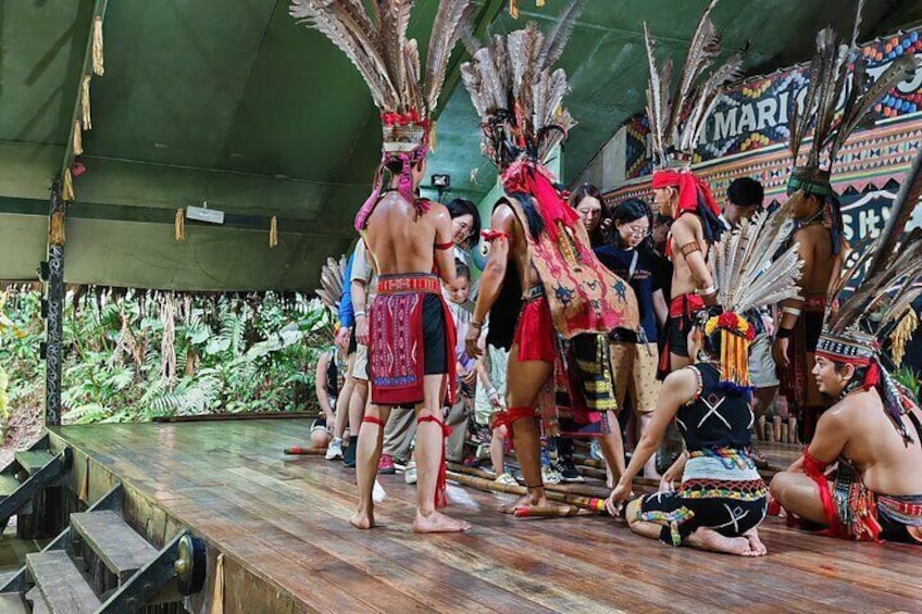 Una presentación de danza tradicional con participantes usando tocados de plumas elaborados y trajes coloridos. 3