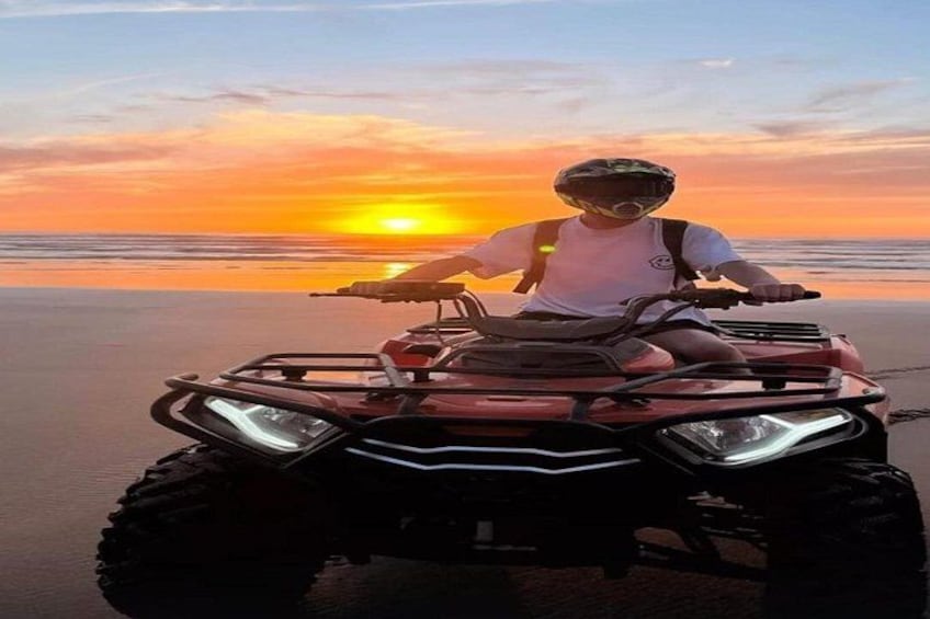 A person on a quad bike at sunset on a beach. 2