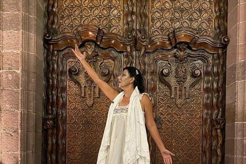 A person standing in front of an intricately carved wooden door. 5
