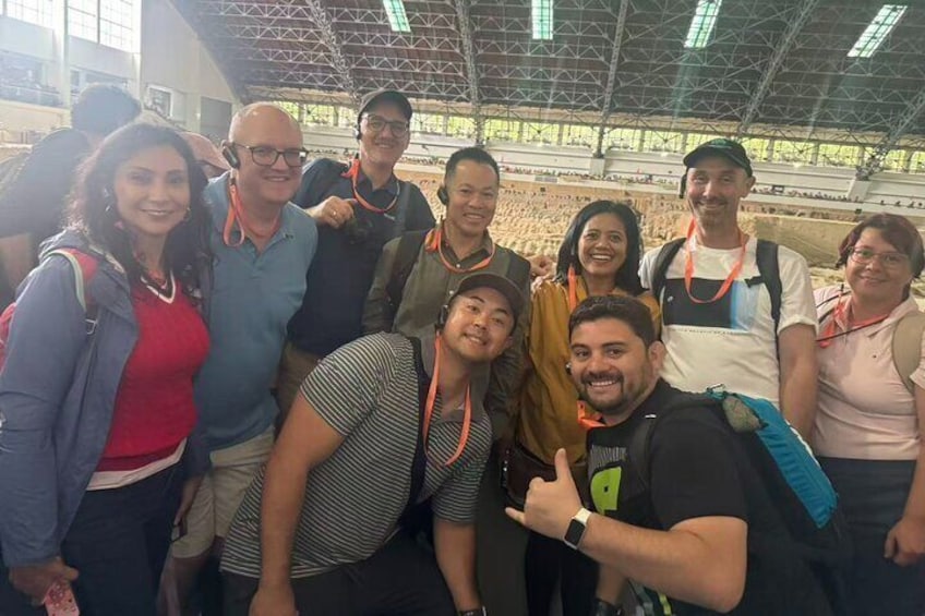 Un grupo de personas posando para una foto en un espacio interior con techos altos y amplias ventanas. 1