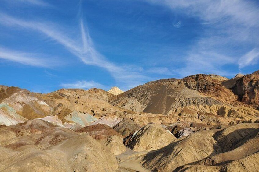 Un paisaje desértico agreste con formaciones rocosas estratificadas y un cielo azul despejado. 3