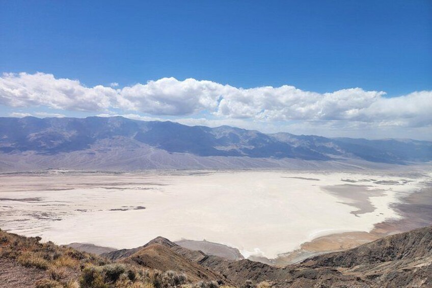 A vast salt flat with mountains in the background under a clear sky. 2