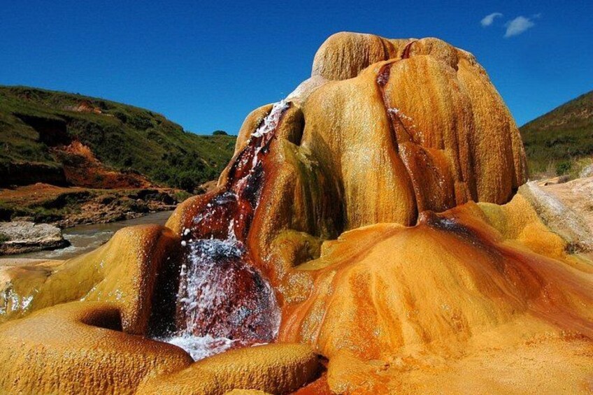 A natural landscape with a waterfall and mineral deposits. 1