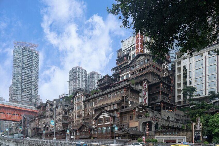 Un edificio tradizionale in legno con più piani e decorazioni elaborate, circondato da moderni grattacieli. 3