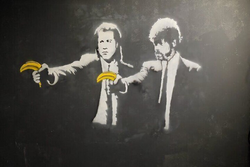A graffiti artwork of two figures holding bananas. 5