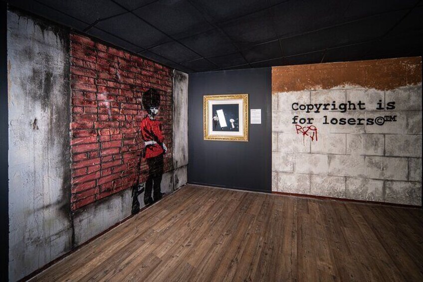 A room with a brick wall, a framed picture, and a sign stating "Copyright is for losers". 3
