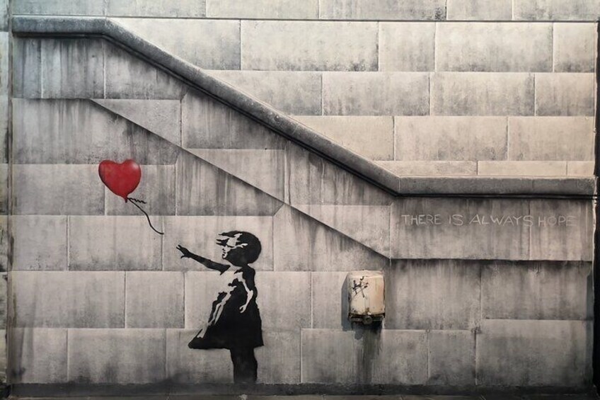 A mural of a girl holding a heart on a wall with the text "THERE IS ALWAYS HOPE". 1