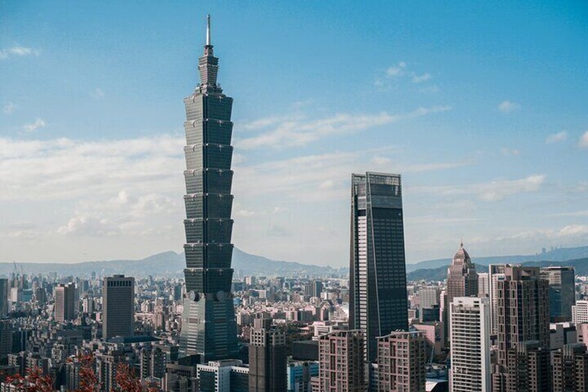 A cityscape with a prominent tower with a unique stepped design and a shorter, rectangular skyscraper. 5