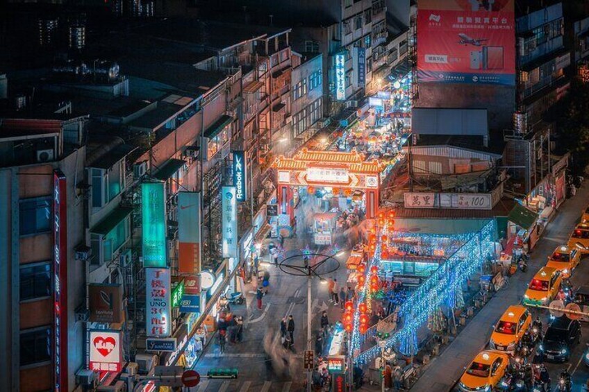 A busy urban street at night with illuminated signs and vehicles. 3
