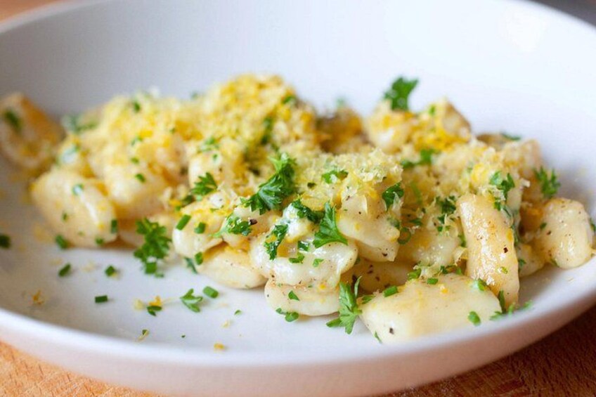 A plate of pasta garnished with herbs and cheese. 3