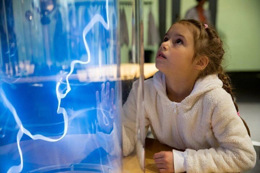 Un enfant observe un récipient transparent contenant un liquide bleu et des motifs blancs. 1