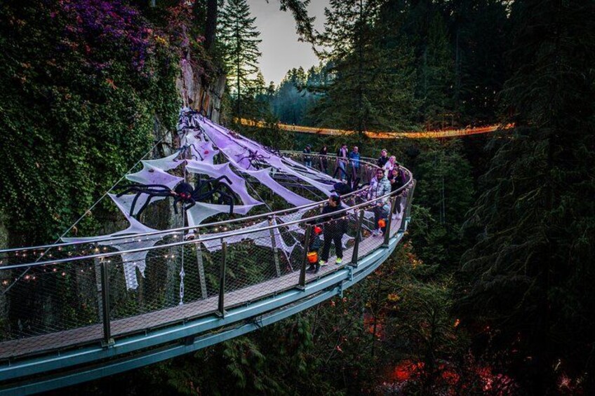 A glass bridge with people walking on it, surrounded by dense forest. 5