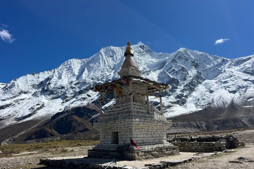 A snow-covered mountain range with a small stone structure in the foreground. 5