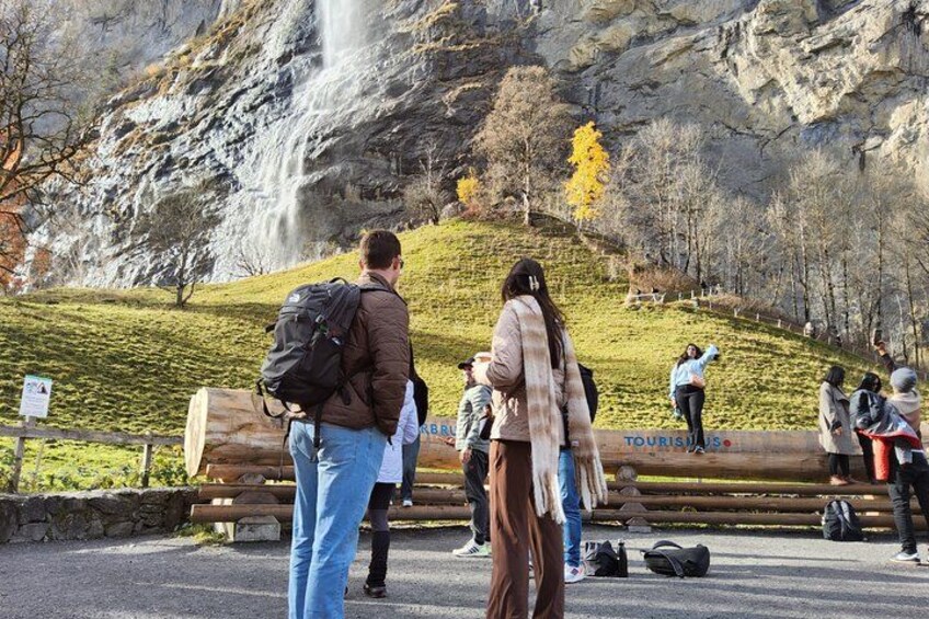 A waterfall, people, and a forested hillside. 2