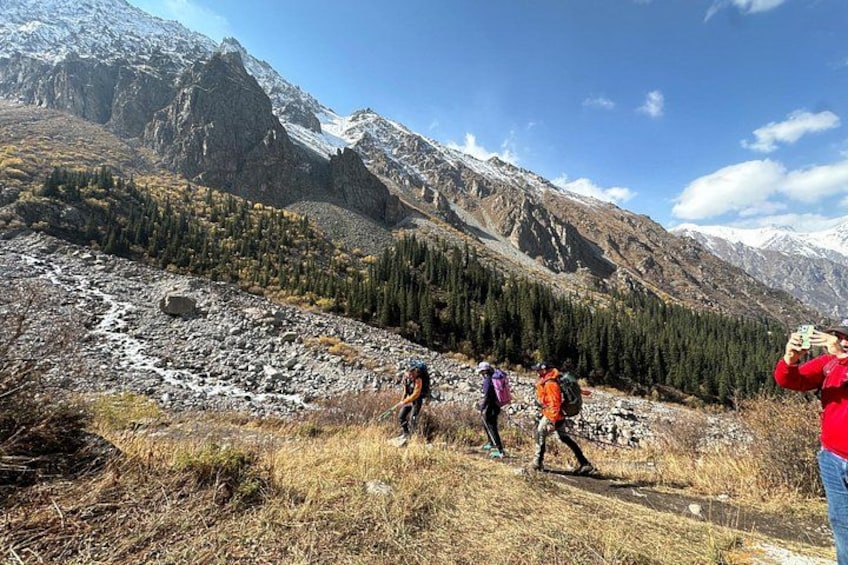 A mountainous landscape with hikers and a person taking a photo. 5