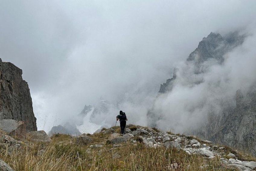 A hiker on a rocky mountain peak with fog. 2