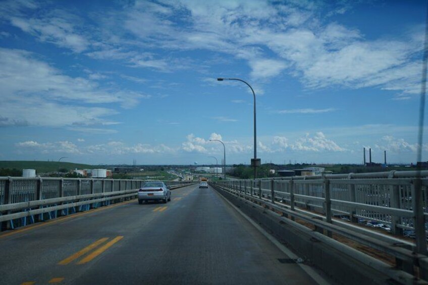 A multi-lane bridge with guardrails, vehicles, and a clear sky. 2