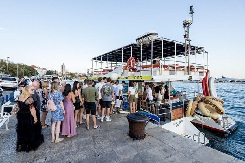 A boat docked at a pier with people boarding and disembarking. 2