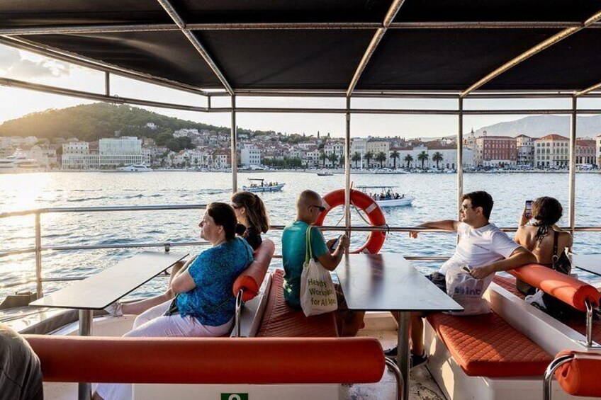 A boat with passengers, a lifebuoy, and a cityscape in the background. 1