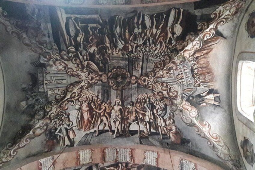 A detailed mural with figures and ornate designs on a wall. 2