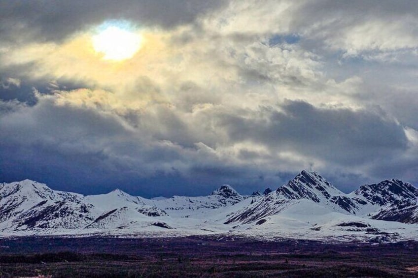 A snowy mountain range under a cloudy sky. 4