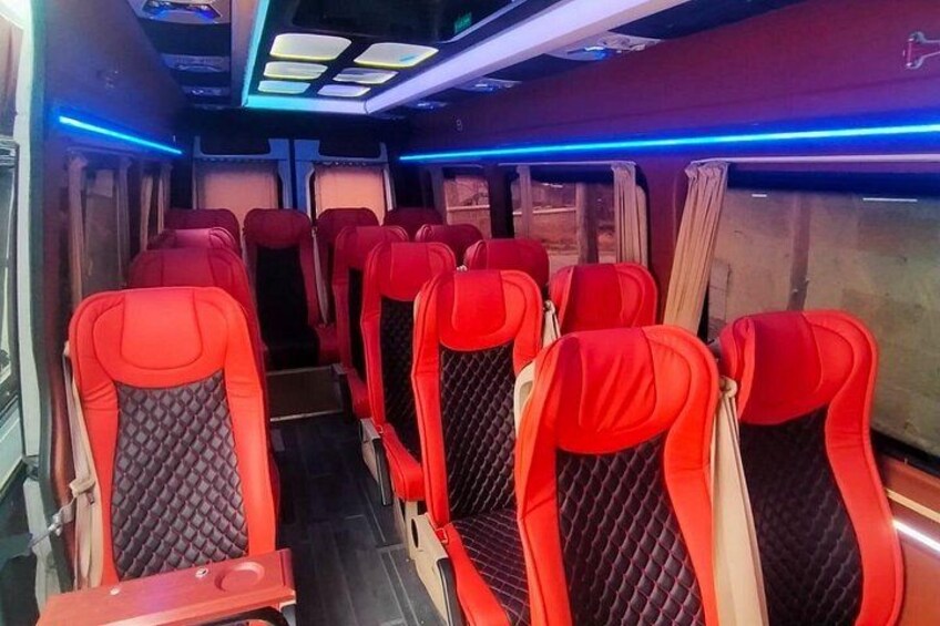 A train interior with red seats and blue lighting. 4