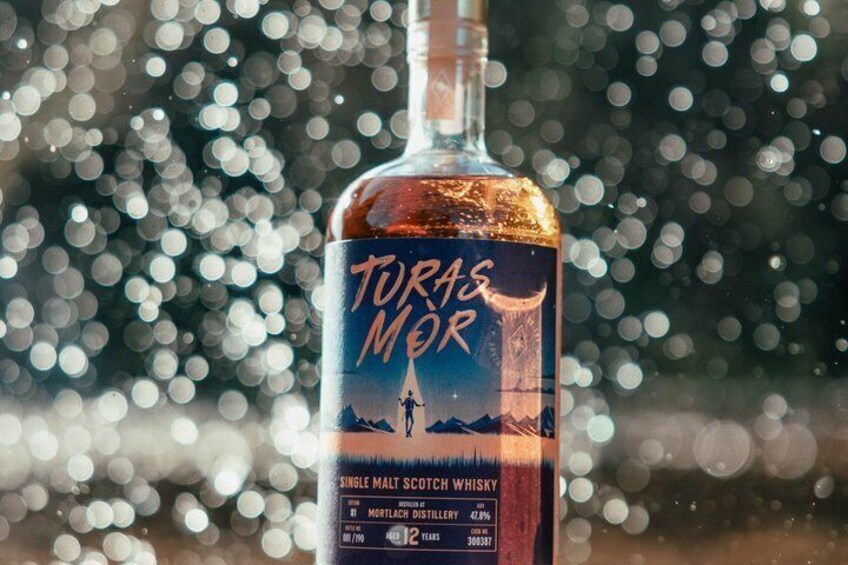 A bottle of Torres Mor single malt scotch whisky with a mountain and moonlit scene on the label. 2