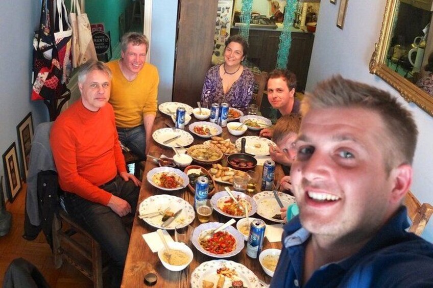 A group of people sitting around a table with various dishes and drinks. 3