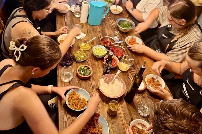 Un grupo de personas sentadas alrededor de una mesa de madera, comiendo y bebiendo. 1