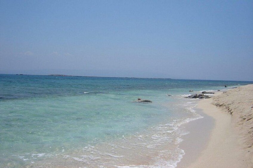 A beach with clear turquoise water, sandy shore, and distant horizon. 5