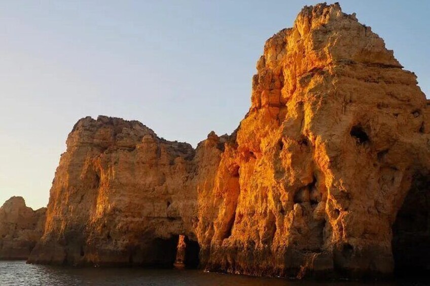 Une grande formation rocheuse au bord de l’eau, au coucher du soleil. 2