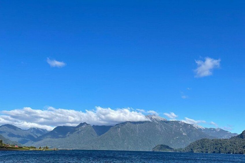 Un lago con montañas al fondo bajo un cielo azul despejado. 1