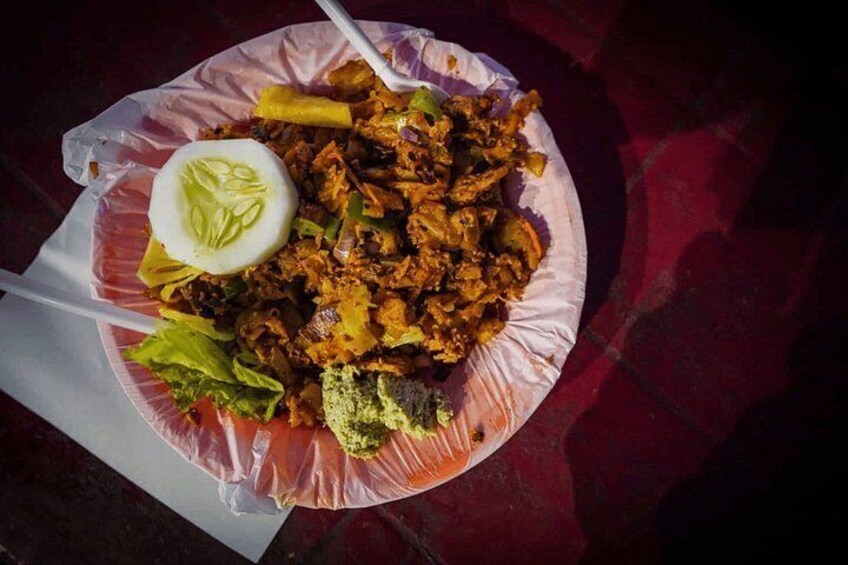 A meal with shredded meat, lettuce, and a slice of boiled egg on a paper plate. 2