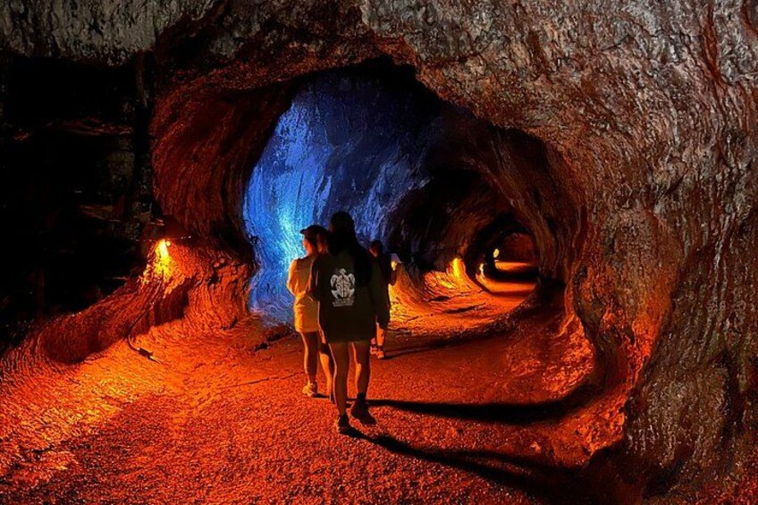Una cueva con una abertura iluminada en azul y personas en su interior. 2