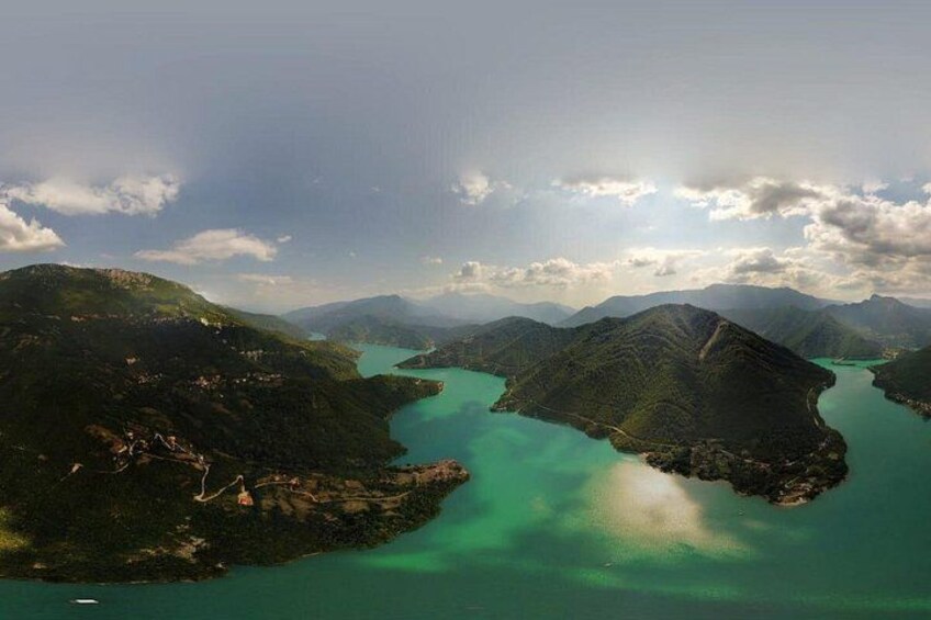 Un paisaje montañoso con un lago turquesa rodeado de exuberante vegetación. 5