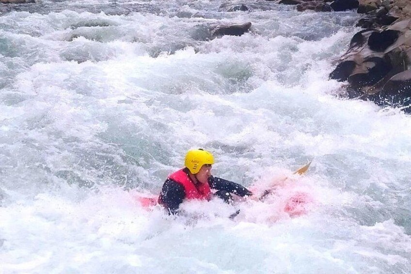 Una persona practica kayak en un río con rápidos. 2