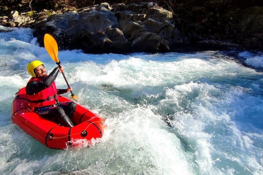 Una persona haciendo kayak en un río con rápidos. 1