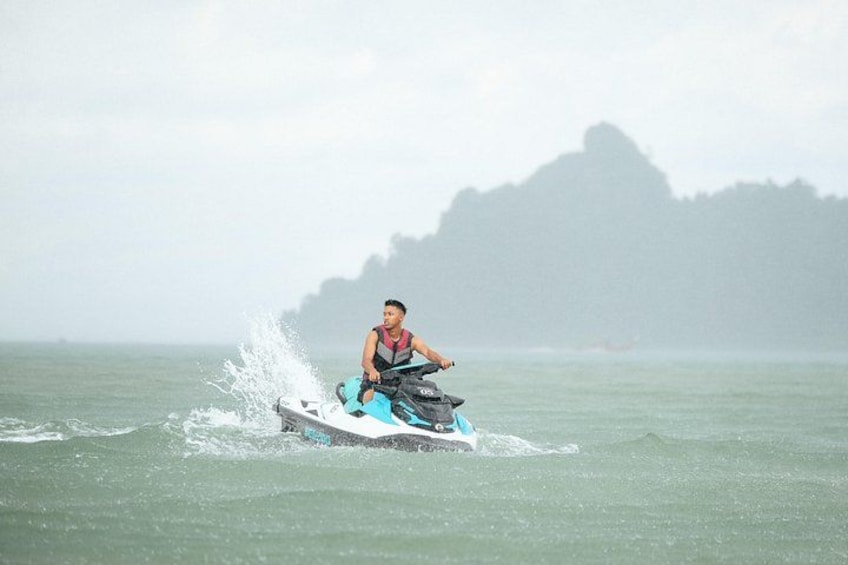 A person riding a jet ski on a body of water with a mountainous landscape in the background. 5