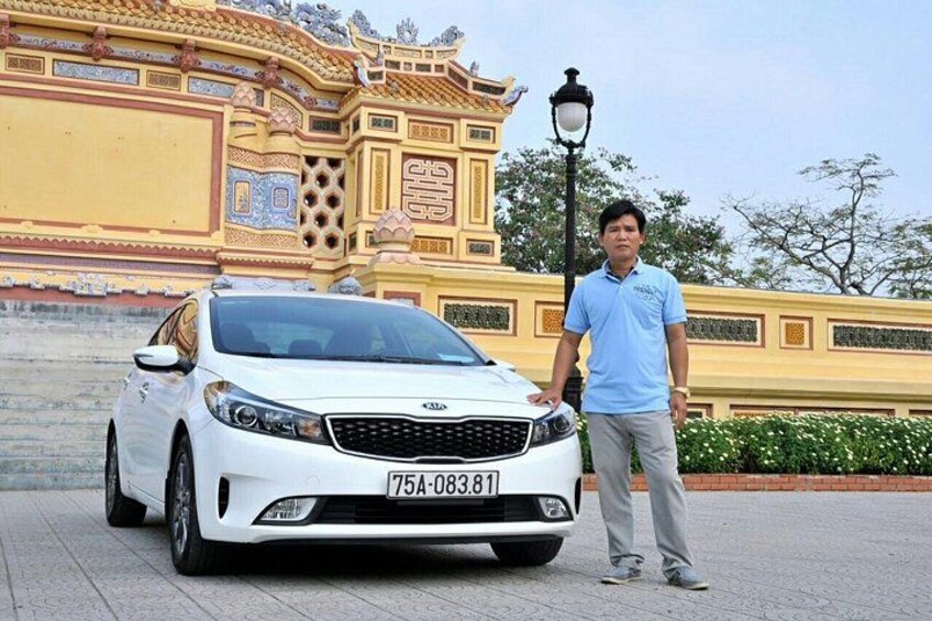 A white car parked in front of a traditional building with intricate designs. 1