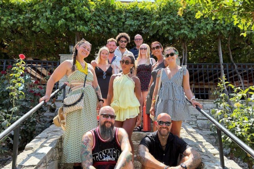 Un grupo de personas de pie en una escalera de piedra rodeada de follaje. 5