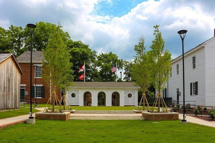 En historisk bygning med hvid facade, buede vinduer og en midterindgang. 3