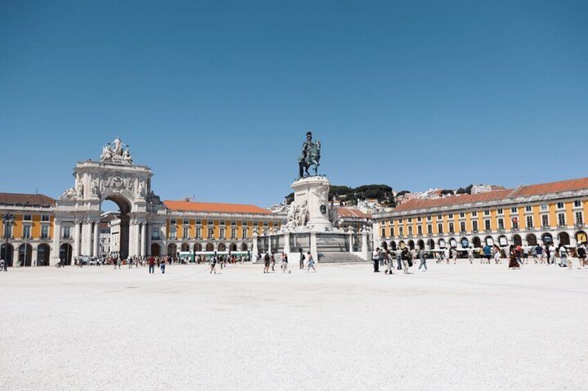 Una amplia plaza abierta con una estatua central, rodeada de edificios históricos con arcos y columnas. 2