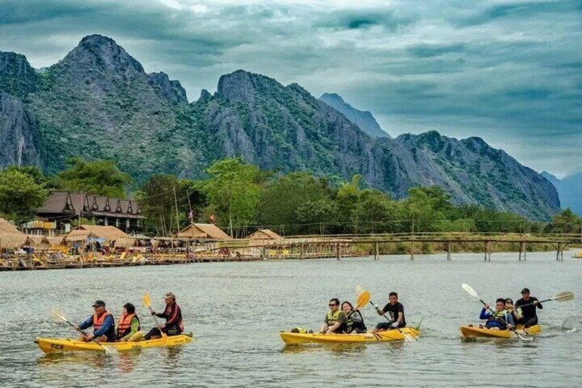 Persone che fanno kayak su un fiume con montagne sullo sfondo. 1
