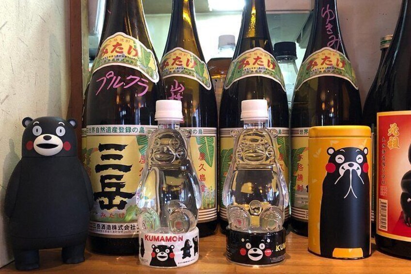 Various bottles of sake with bear-themed labels, a bear figurine, and a small bear-shaped bottle. 4