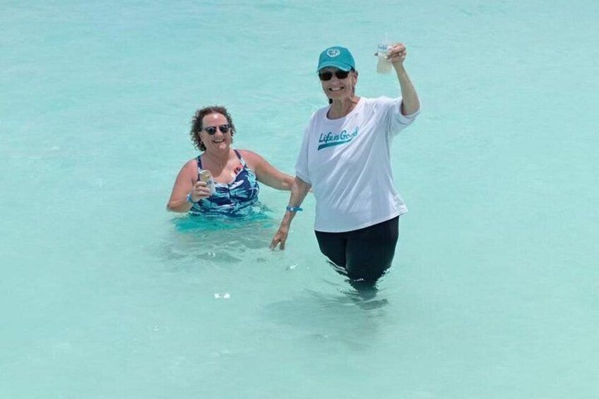 Two people walking in shallow clear water. 2